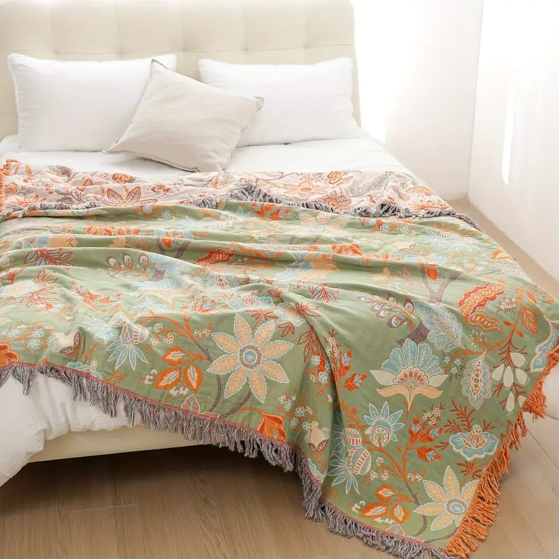 Blomstret boho-pledd i bomull med frynser i oransje og blått