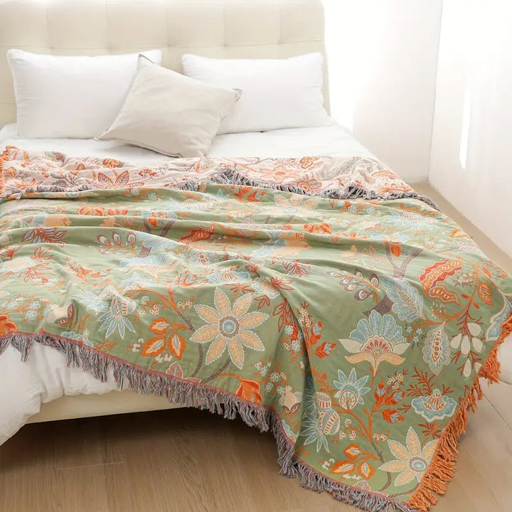 Blomstret boho-pledd i bomull med frynser i oransje og blått