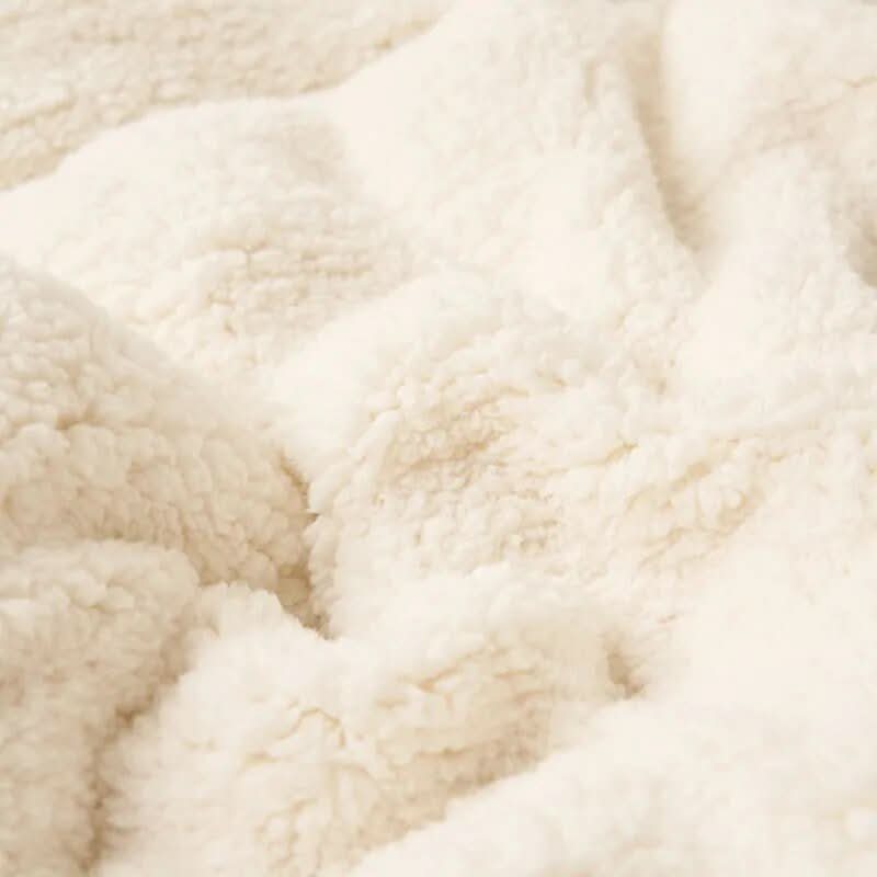 Vendbart sherpateppe i fleece til seng og sofa